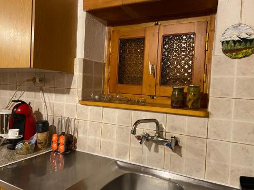un comptoir de cuisine avec un évier et une fenêtre dans l'établissement Σπίτι στο βουνό, à Tsivlós