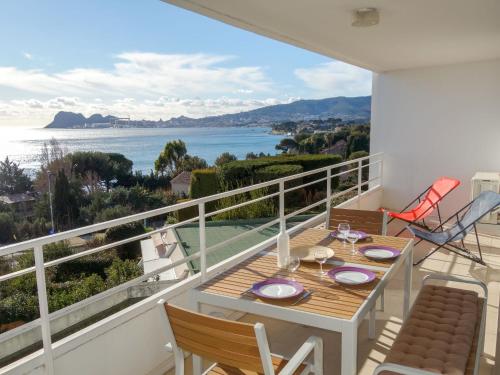 een balkon met een tafel en stoelen en uitzicht op het water bij Apartment Les Hauts de Fonsainte by Interhome in La Ciotat