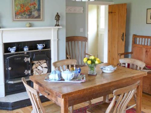 een eetkamer met een houten tafel en een open haard bij Brookleigh in Hutton le Hole