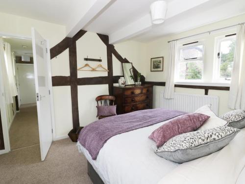 ein Schlafzimmer mit großem Bett und Fenster in der Unterkunft Causeway Cottage in Pencombe