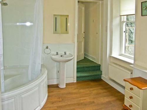 a white bathroom with a sink and a shower at Bryn Cemlyn in Llanfachreth
