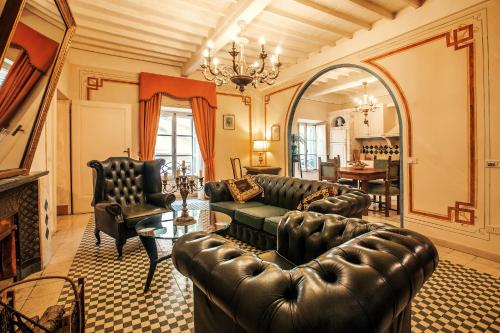 a living room with leather furniture and a fireplace at Palazzo Barbini Dimora Storica in Castiglione del Lago