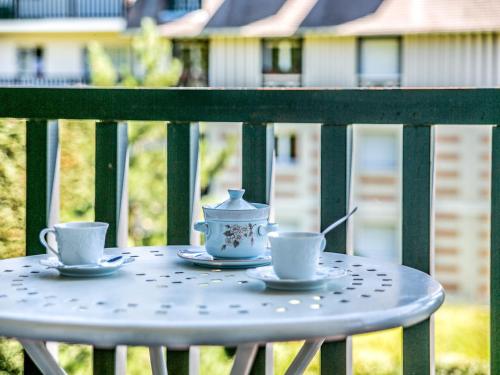 two cups and saucers on a table on a balcony at Studio Les Corniches du Mont Canisy-3 by Interhome in Blonville-sur-Mer