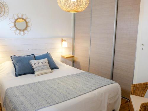 ビアリッツにあるApartment Elaura by Interhomeのベッドルーム(青い枕と鏡付きのベッド1台付)