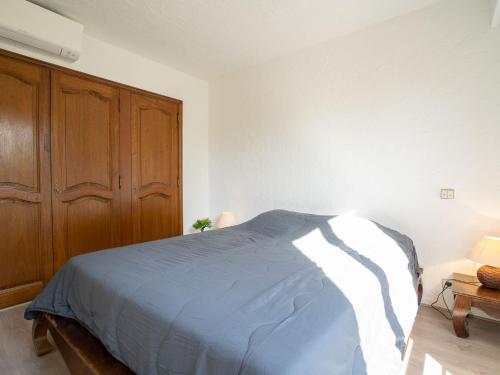 une chambre avec un lit et une armoire en bois dans l'établissement Apartment L'Orée de Vence by Interhome, à Vence