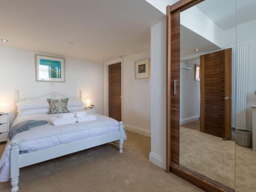 a bedroom with a white bed and a mirror at Hepworth Apartment in St Ives