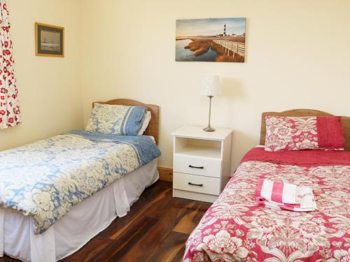 a bedroom with two beds and a night stand with a lamp at Clash-Brack in Dungarvan