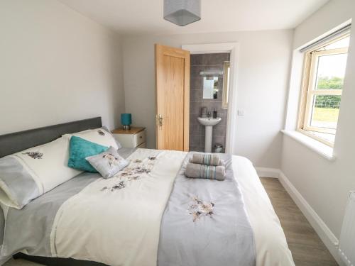 a bedroom with a bed and a sink and a window at Dromstabla in Glencar