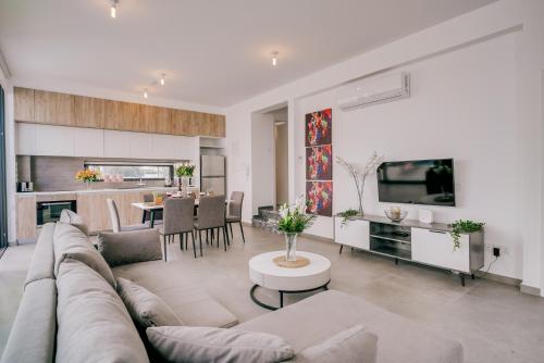 a living room with a couch and a table at SunnyVillas: 2BR New Villa☆Private Pool in Pernera - Nicholas in Protaras