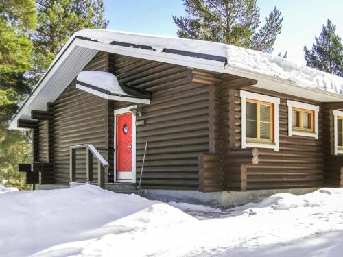 a log cabin with a red door in the snow at Holiday Home Mäkrä 1 by Interhome in Kolinkylä