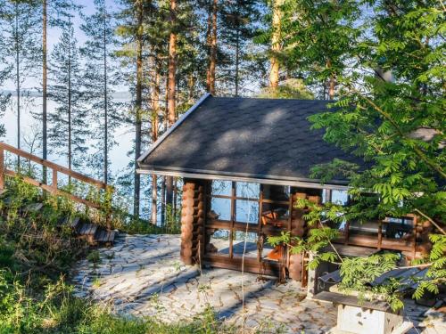 a log cabin in the woods with a path leading to it at Holiday Home Mäkrä 1 by Interhome in Kolinkylä