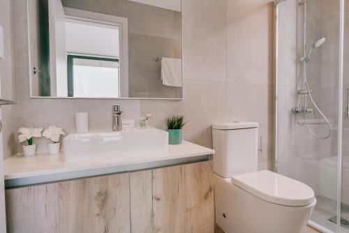 a bathroom with a sink and a toilet and a mirror at SunnyVillas: 2BR New Villa☆Private Pool in Pernera - Nicholas in Protaras