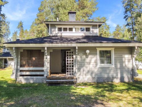 ein kleines weißes Haus auf einem Grasfeld in der Unterkunft Holiday Home Karjalan veikko 2 b by Interhome in Hattusaari