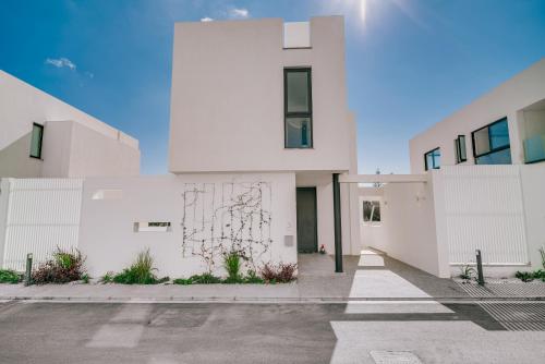 an empty parking lot in front of a white building at SunnyVillas: 2BR New Villa☆Private Pool in Pernera - Nicholas in Protaras