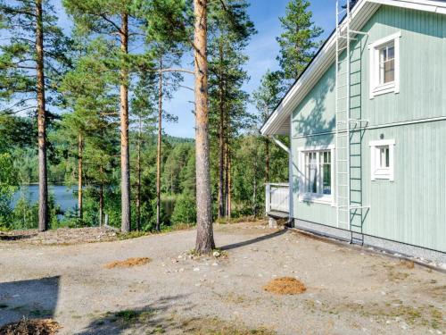 ein grünes Haus mit einem Baum neben einem Gebäude in der Unterkunft Holiday Home Saunaharju 3 by Interhome in Kolinkylä