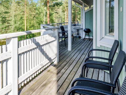 eine Veranda mit Stühlen und Tischen auf einem Haus in der Unterkunft Holiday Home Saunaharju 3 by Interhome in Kolinkylä
