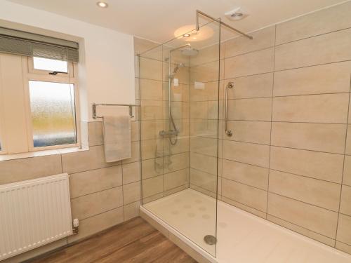 a bathroom with a shower with a glass door at Meadow Cottage in Keighley