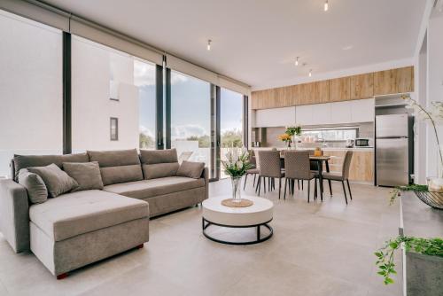 a living room with a couch and a table at SunnyVillas: 2BR New Villa☆Private Pool in Pernera - Nicholas in Protaras