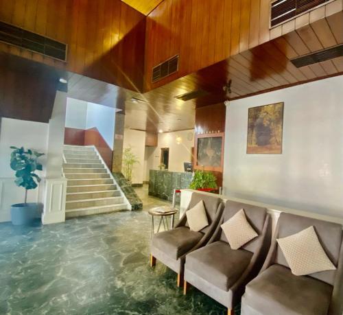 ディマプルにあるHotel Tragopanの椅子付きのロビーと水の入ったフロア