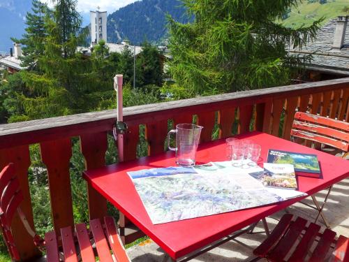 a red table with glasses on a balcony at Apartment Arvine combles by Interhome in Verbier