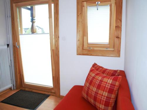 a living room with a red couch and two windows at Gielerhof in Zell am Ziller