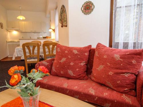 um sofá vermelho com almofadas numa sala de estar em Apartment Lanovka-2 by Interhome em Jáchymov