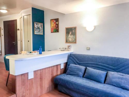 Studio Les Marinas-10 by Interhome في دوفيل: غرفة معيشة مع أريكة زرقاء ومكتب