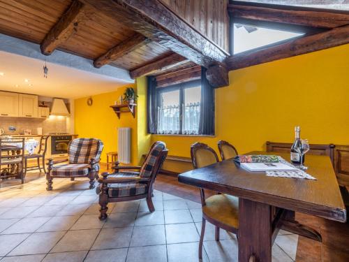 kuchnia i jadalnia z drewnianym stołem i krzesłami w obiekcie Apartment Maison Chez Nous by Interhome w mieście Sarre