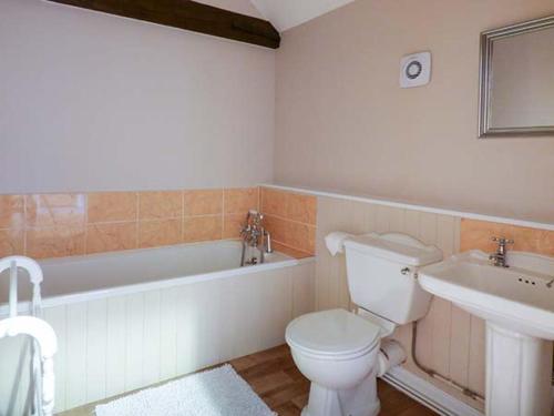 a bathroom with a toilet and a tub and a sink at Stable View in Hingham