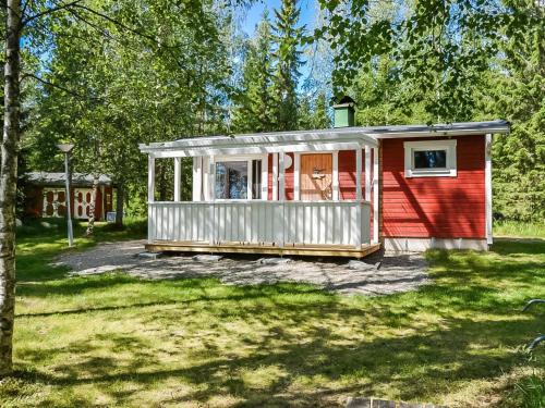 una casita roja y blanca en un patio en Holiday Home Västäräkki by Interhome en Urimolahti