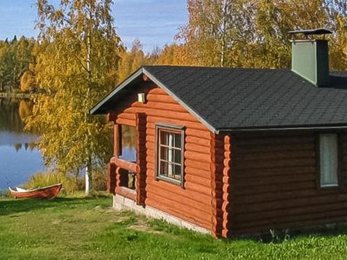 uma cabana de madeira ao lado de um lago em Holiday Home Palokärki by Interhome em Urimolahti