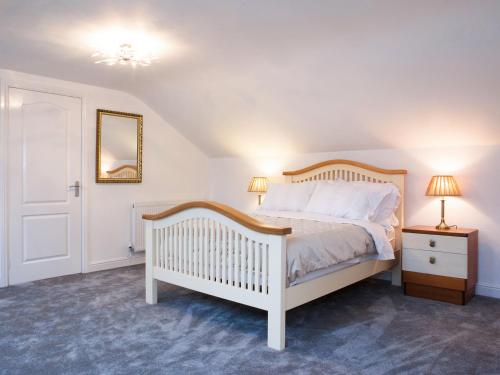 a bedroom with a white bed and a mirror at Riverdale in Shrewsbury