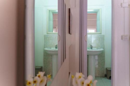 a bathroom with two sinks and two mirrors at Sansi´s Sapri Camere in Sapri