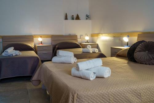 a room with three beds with towels on them at Sansi´s Sapri Camere in Sapri