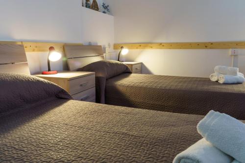 a hotel room with two beds and a lamp on a desk at Sansi´s Sapri Camere in Sapri