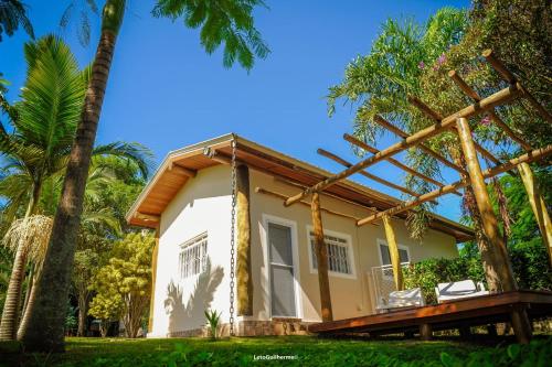 een huis met een veranda en palmbomen bij Cantinho do Paraíso in Socorro