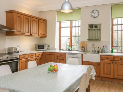 a kitchen with a table with a bowl of fruit on it at Hoath House in Chiddingstone