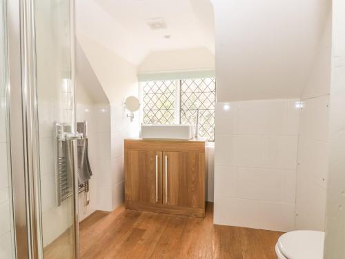 a bathroom with a toilet and a glass shower at Hoath House in Chiddingstone