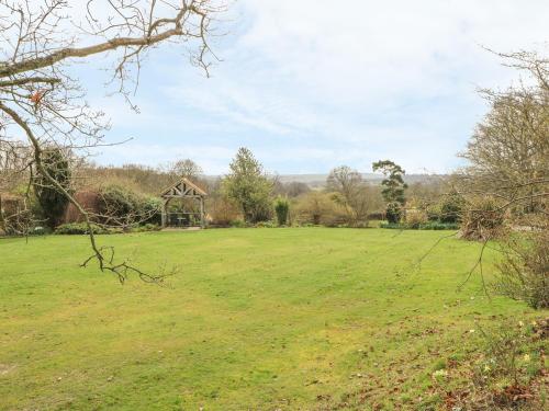 a large field with a gazebo in the distance at Hoath House in Chiddingstone