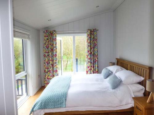 a bedroom with a large bed and a window at Crook Lodge in Cartmel
