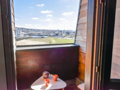 une fenêtre avec deux tasses sur une table devant elle dans l'établissement Studio Les Marinas-11 by Interhome, à Deauville