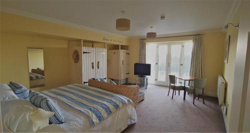 a hotel room with a bed and a table and a television at Patricks Boathouse in Swansea