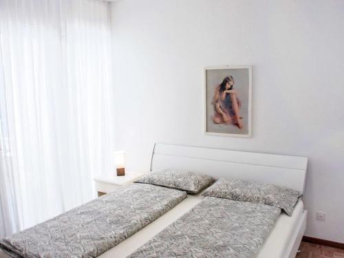 a bedroom with two beds and a painting on the wall at Apartment Apt- Lugano Majestic Panorama by Interhome in Lugano