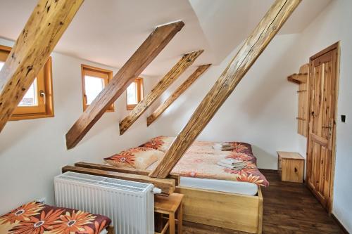a bed in a room with wooden beams at Strnadovský mlýn in Jesenice