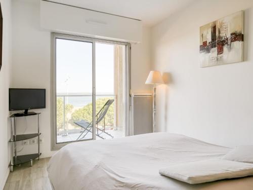 une chambre blanche avec un lit et une grande fenêtre dans l'établissement Apartment Claire-1 by Interhome, à Arcachon