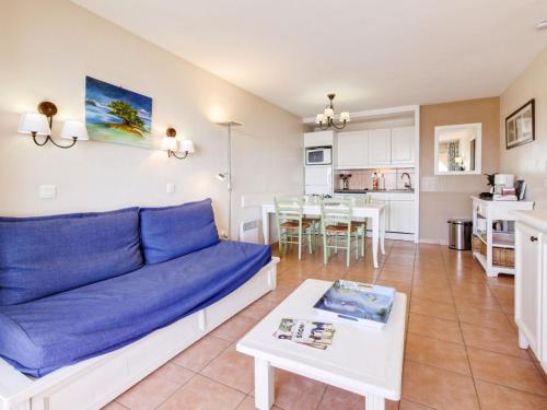- un salon avec un canapé bleu et une table dans l'établissement Apartment Les Rivages de Coudoulière-29 by Interhome, à Six-Fours-les-Plages