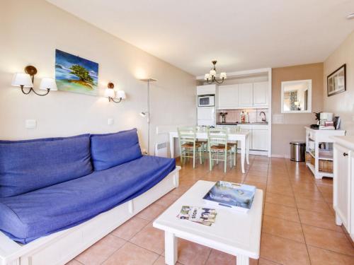 un salon avec un canapé bleu et une table dans l'établissement Apartment Les Rivages de Coudoulière-29 by Interhome, à Six-Fours-les-Plages