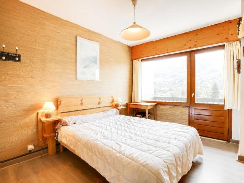 une chambre avec un lit et une grande fenêtre dans l'établissement Apartment Le Sarto by Interhome, à Saint-Gervais-les-Bains