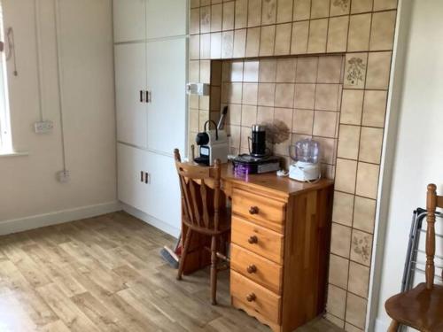 a kitchen with a wooden table and a counter top at Hardy’s Cottage in Doolin