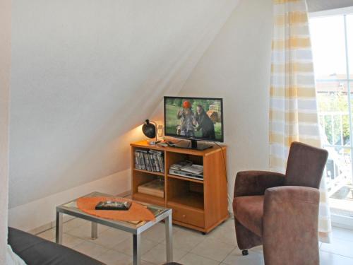 a living room with a tv and a chair at Apartment FIP-Ferienpark - Insel Poel-1 by Interhome in Gollwitz